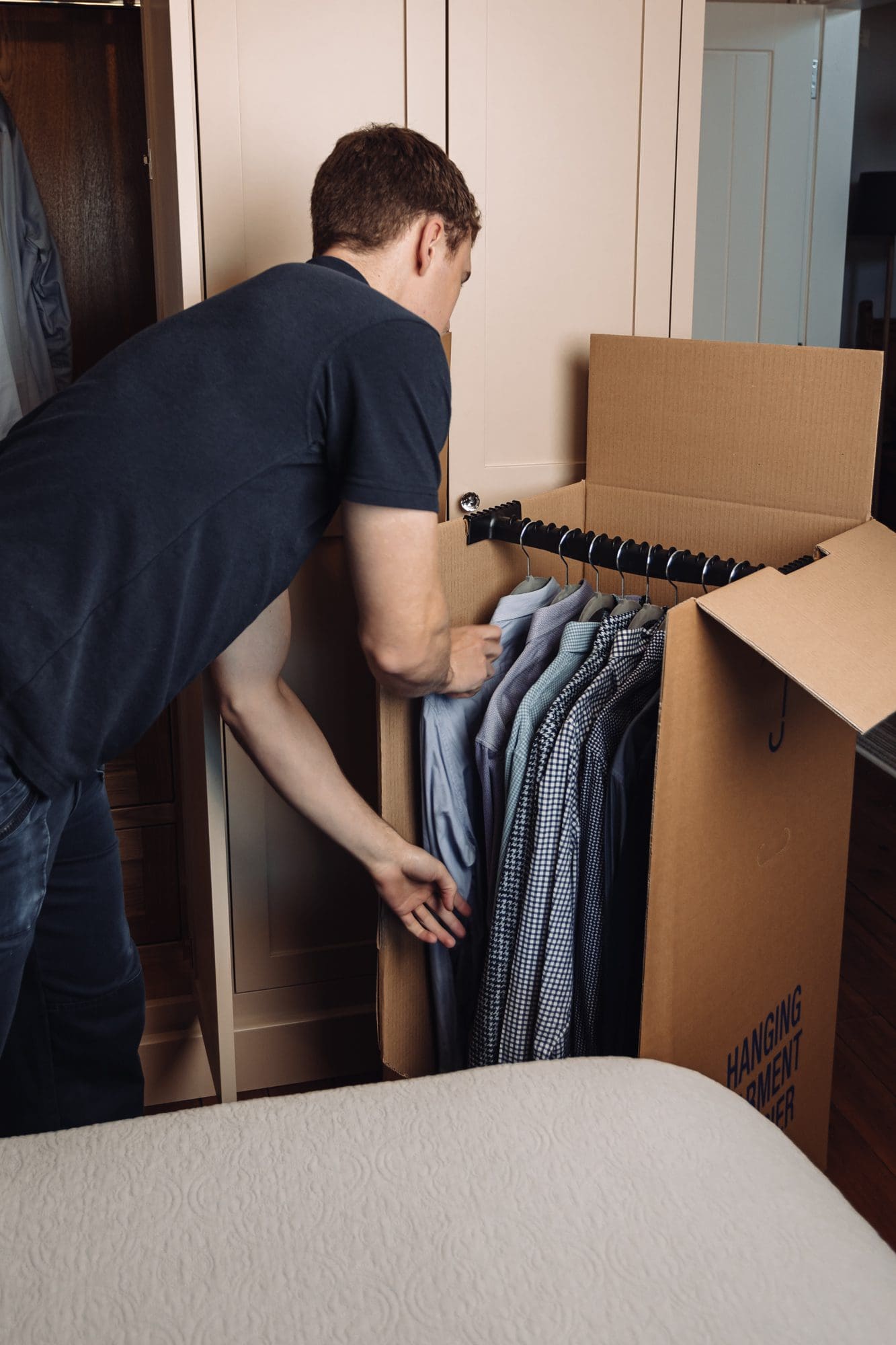 A man arranging clothes in a box