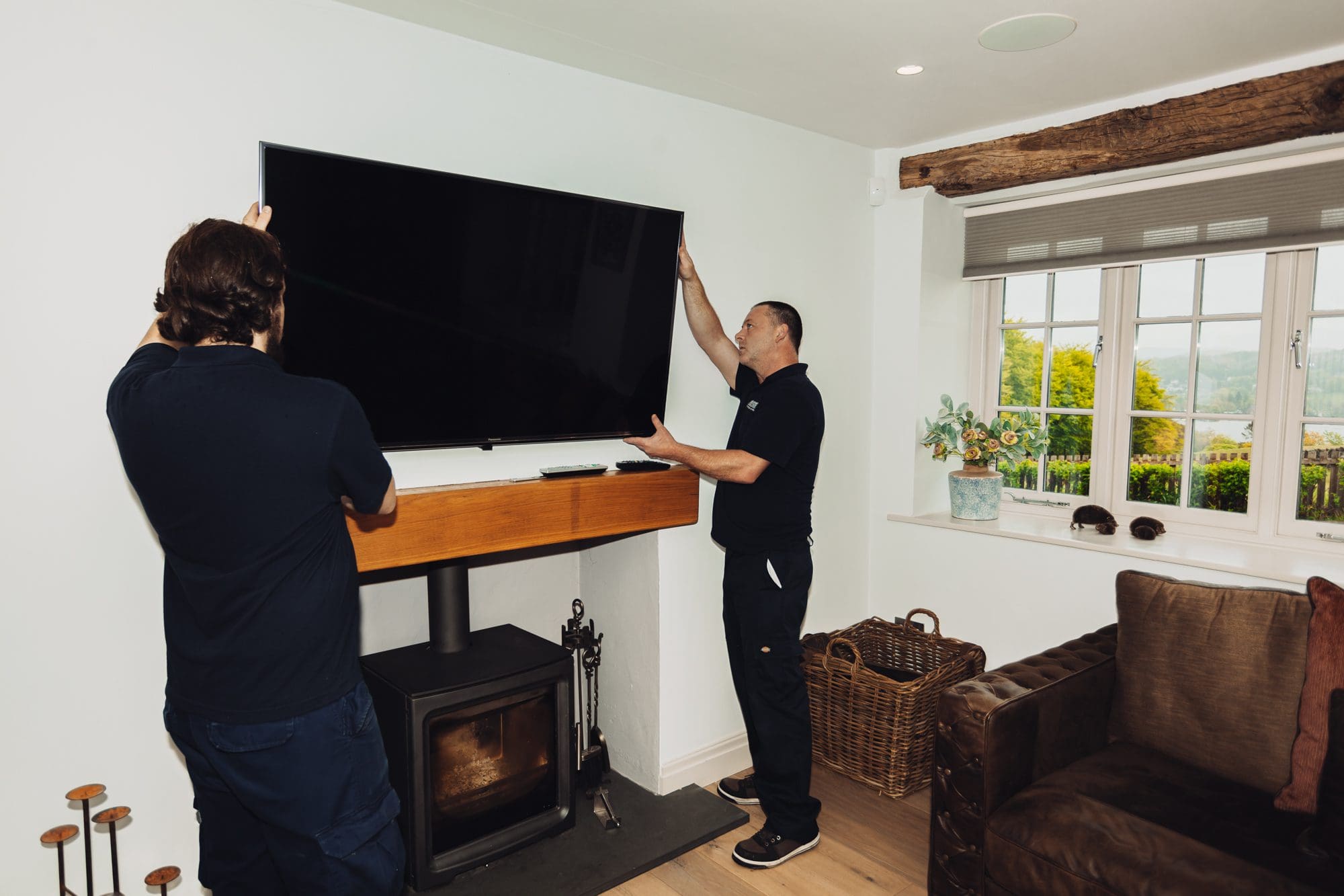 men removing attached tv from the wall